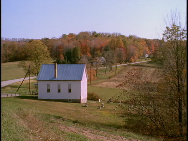 A country road winds beside a farmhouse.