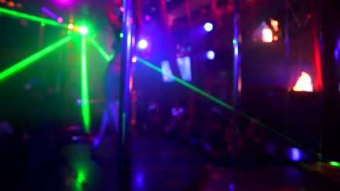 Defocused view, sexy woman dancing on a stage in a strip club.