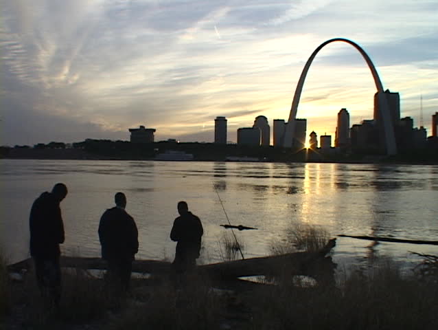 Fishermen gaze across the Mississippi river at the St. Louis arch.