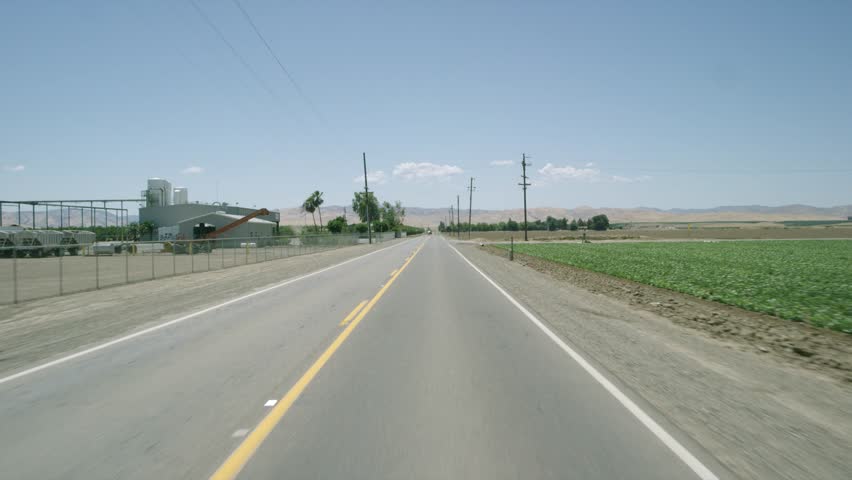 Farmland: Stanislaus County, CA USA Set 1 - Driving Plate Direct Front angle: Car travels W on country road on a clear day with no traffic. Shot on RED Dragon.