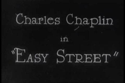 CIRCA 1920s - A clip of Charlie Chaplin in the silent film, Easy Street in 1920s, shows Charlie trying to free someone's head from inside a lamppost.