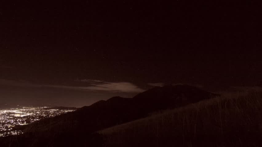 A beautiful night time time lapse over a city in a mountain valley.