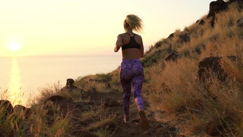 Young Athletic Woman Running on Mountain Trail. POV Follow Cam. Sunset Workout in Nature. Slow Motion