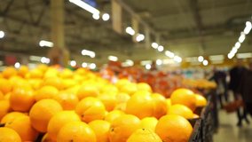Unrecognizable customers in supermarket choose oranges, slow motion video