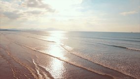 Aerial drone footage of sea waves during sunny day. Tracking shot fit woman is standing with hands on hips at shore. This video is filmed from a high angle perspective.
