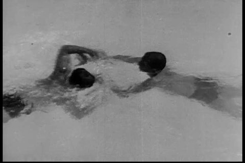 CIRCA 1930s - The wrist lock and back headlock release grips in 1933, shown by a U.S. swimmer and lifeguard on a drowning victim.