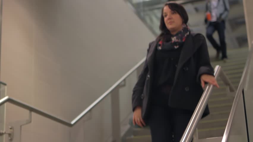 Attractive woman walks down the stairs at the train station