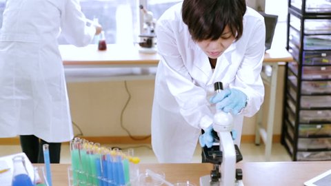 Chinese scientist looking through microscope