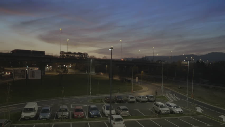 Aerial, dolly rear view along parking lot , sunset, sunrise