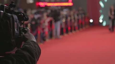 Videographer shoots festive event. A professional cameraman shoots video while passing celebrities on the red carpet. Close up