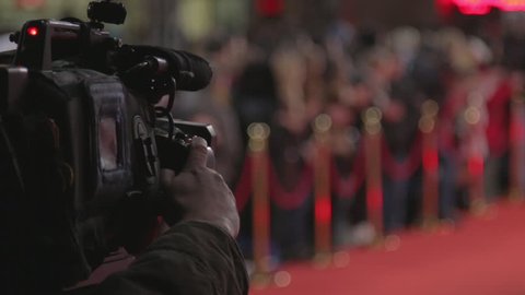 Videographer shoots festive event. A professional cameraman shoots video while passing celebrities on the red carpet