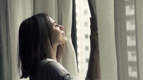 Businesswoman unveil curtains and admire view from window, super slow motion 240fps
