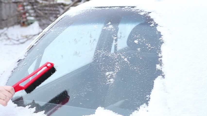 Woman in a red jacket to clear snow from the car window. | Shutterstock HD Video #13905110
