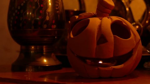 Ungraded: Jack-o'-lantern. Candle burning inside a clay pumpkin. Source: Lumix DMC, ungraded H.264 from camera without re-encoding. (av23033u)