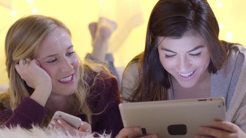 Friends Talk And Laugh As They Watch A Funny Video On A Tablet 