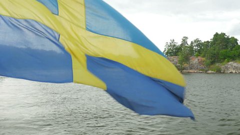 ship with swedish flag moving in sunset, stockholm, sweden