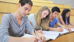 Side view of serious Caucasian students listening a lecturer in an amphitheater - Powered by Shutterstock - Get 15% off with code: PIKWIZARD15