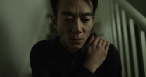 Depressed, sad Asian man looking at camera. Shot on RED Epic.