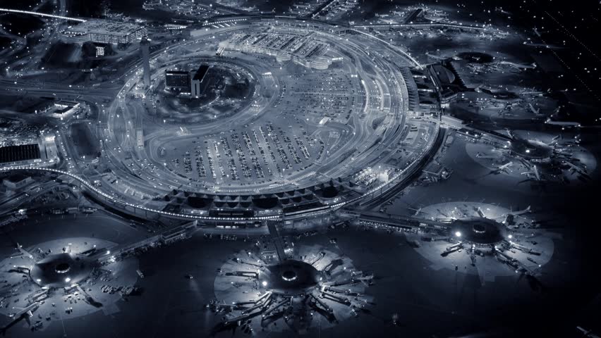 helicopter establishing shot of airplanes parking at international airport terminal at night. global business background
