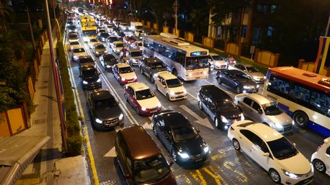 KUALA LUMPUR, MALAYSIA - FEBRUARY 26, 2015: Motorbike jostle through traffic jam, evening rush hour, top perspective view on long vehicle congestion. Motorcycles trickily drive between still vehicles