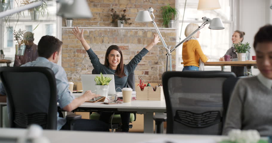 Business woman with arms raised celebrating success watching sport victory on laptop diverse people group clapping expressing excitement in office