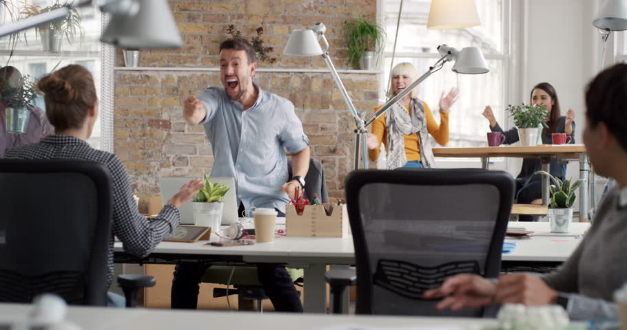 Businessman with arms raised celebrating success watching sport victory on laptop diverse people group clapping expressing excitement in office