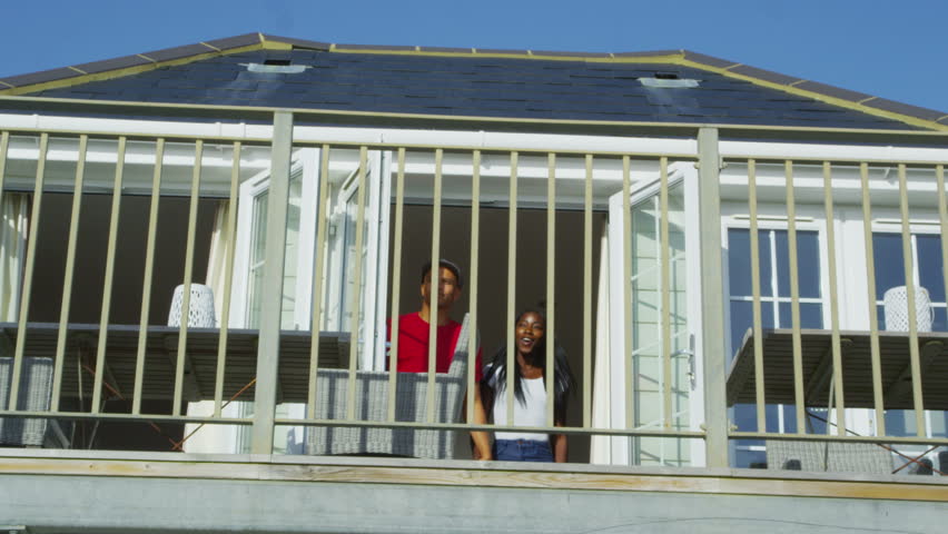 4k / Ultra HD version Happy attractive young couple on vacation go out on the balcony to look at the view. Shot on RED Epic