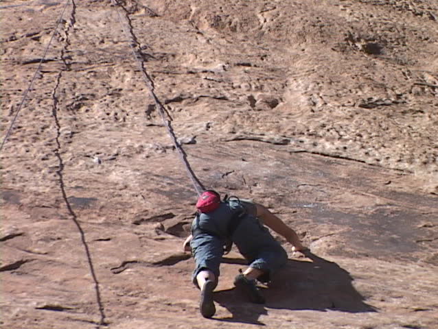 A rock climber scales a wall.
