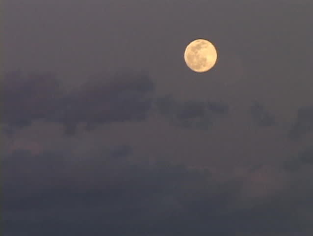 The moon rises in the sky.