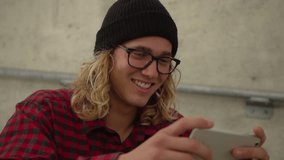 Slow Motion Young Hipster Man Laughing And Smiling While Looking At Phone 