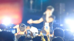 people with smartphones at concert shooting rock star
