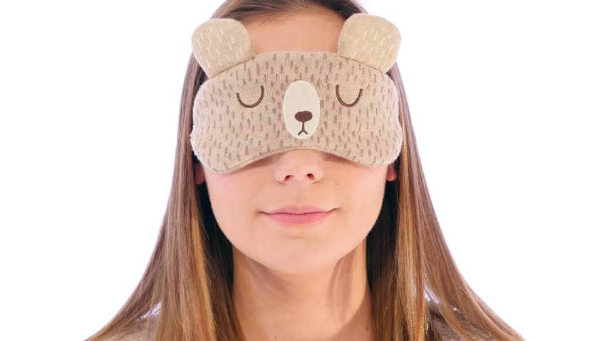 Young Woman with a Cute Sleep Mask Holding it up and Smiling