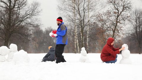 mother and little daughter make snowman, father with son rolled big snowball in winter, part 2