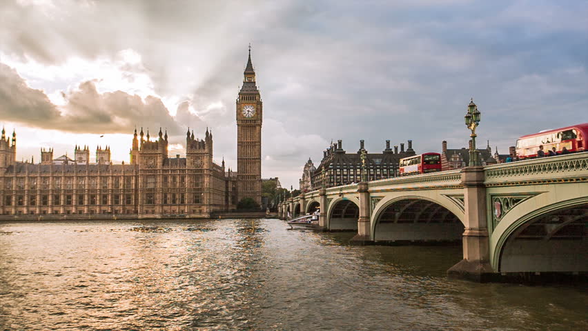 Sunset at Big Ben in England, UKRed buses and boats pass over Westminster Bridge in foreground of London's historical and iconic landmark Royalty-Free Stock Footage #13982474