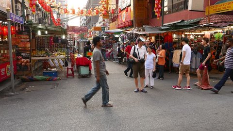 KUALA LUMPUR, MALAYSIA - FEBRUARY 28, 2015: POV rush through China town area market, stalls, crowd, restaurants. Colorful yellow and red-orange umbrellas hang above the street, chinese lifestyle
