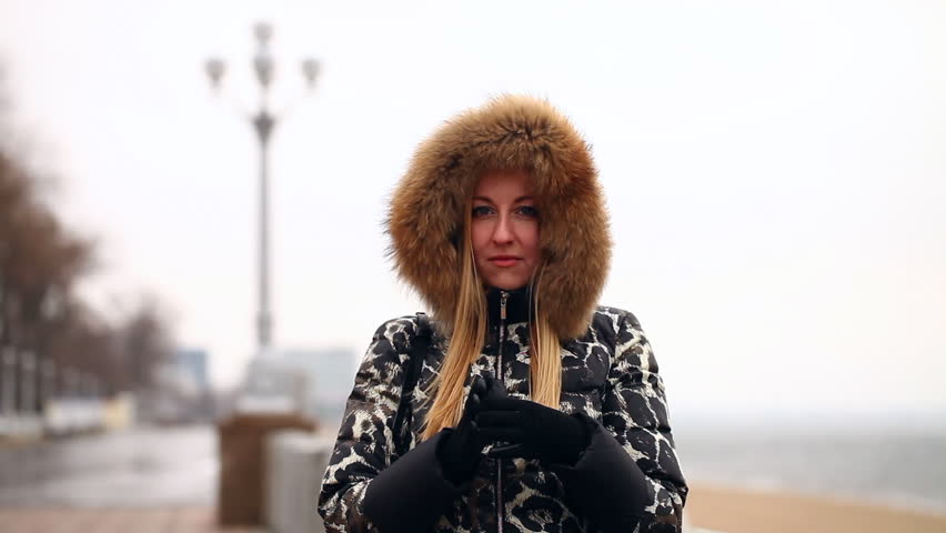 young beautiful girl in winter jacket with fur hood outdoor