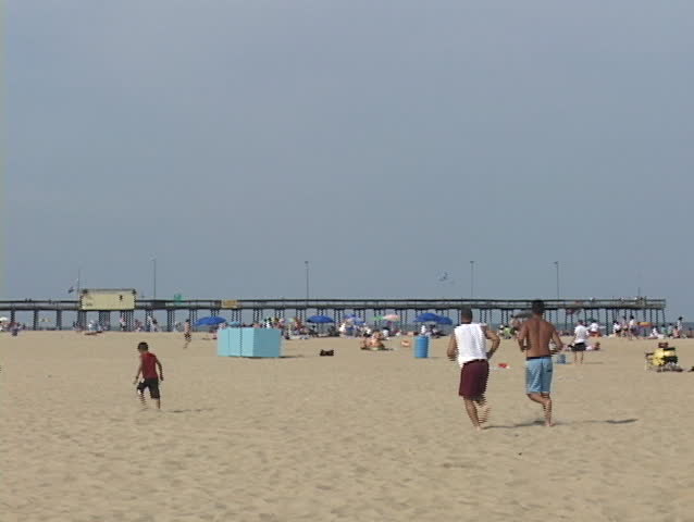 Medium shot of a summer beach scene at Atlantic City, New Jersey with amusement park in background.