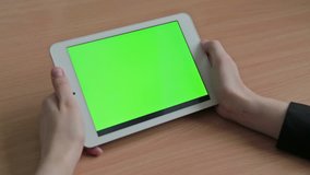 Woman watching videos on tablet, green screen