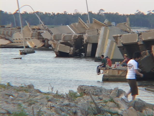 Men fish along a destroyed causeway on the Gulf Coast of Mississippi following Hurricane Katrina.