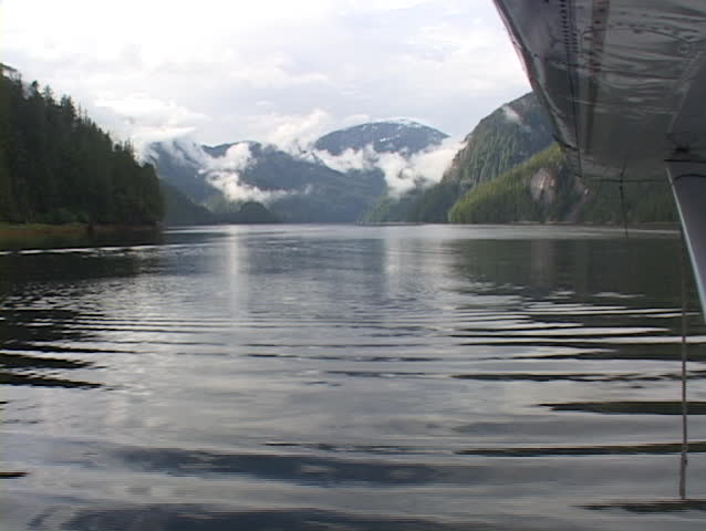A float plane taxis away from the dock in this beautiful Alaska shot.