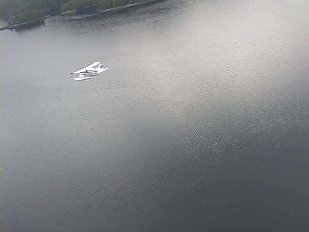 An aerial of a float plane flying over Alaskan fjords.