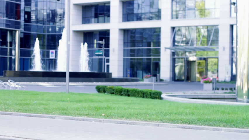 A beautiful young caucasian business woman walking outside office building