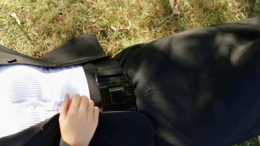Beautiful business woman relaxing on grass with laptop