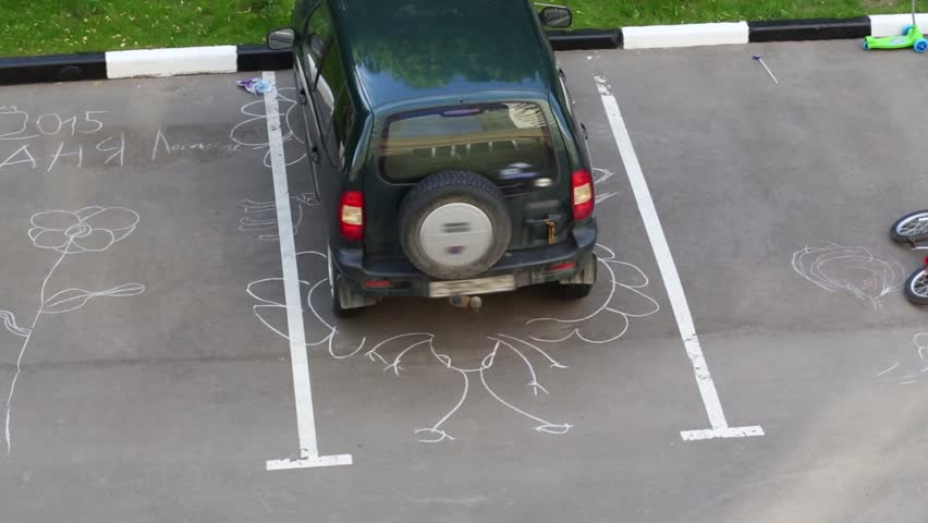 Different chalk drawings on car parking. Text: Anya Losevskaya