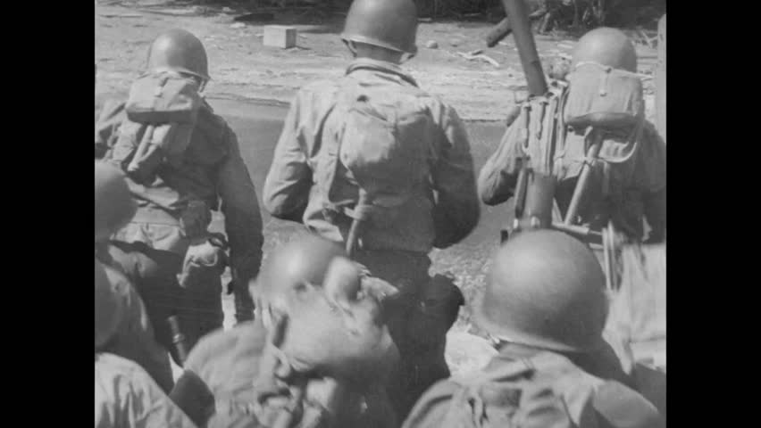 Soldiers jumping off boat and running towards shore