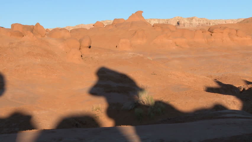 Various hoodoos cast shadows during sun rise around Goblins State Park