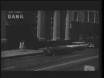 Person in convertble pulling up in front of bank, 1960s