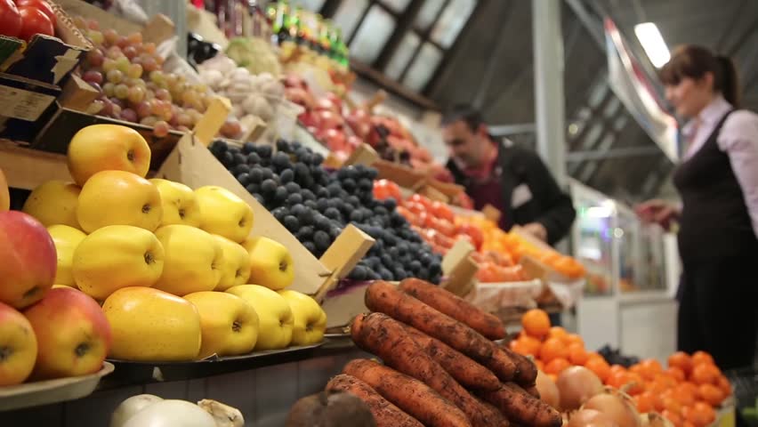 Woman buys vegetables at a farm market. Showcase with lots of vegetables and fruits | Shutterstock HD Video #14040068