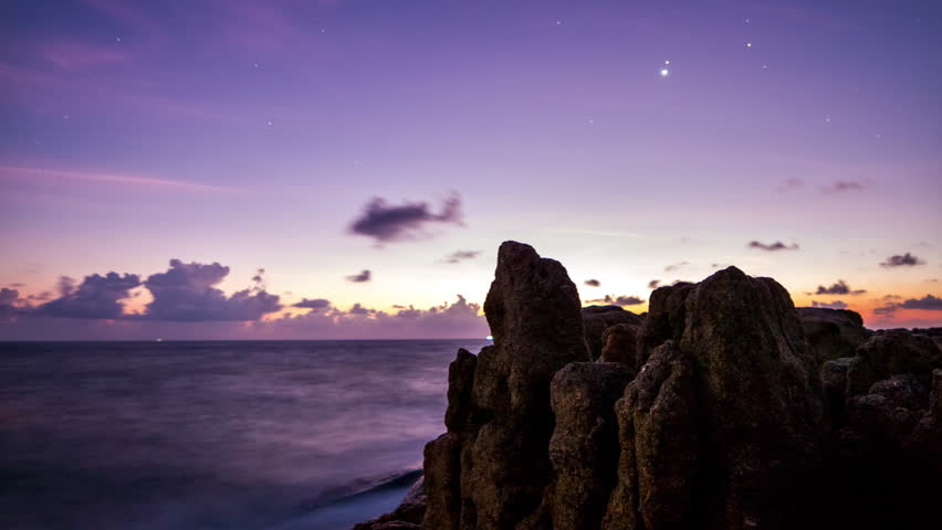 Dawn over rocks and sea  .4K time-lapse