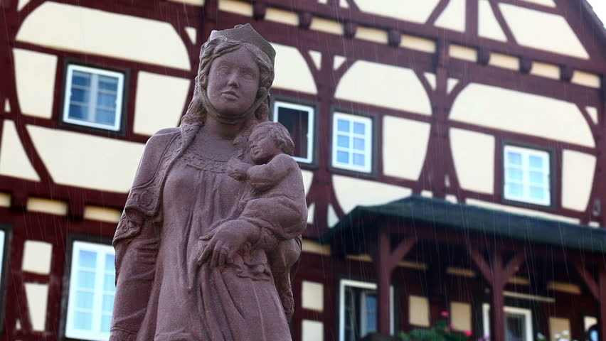a statue in front of a old house